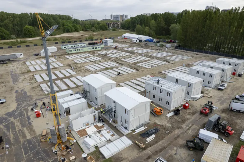 Kraan stapelt containerunits tot blokken van twee verdiepingen