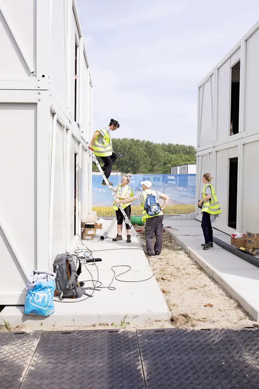 Medewerkers aan het werk tussen twee woonblokken
