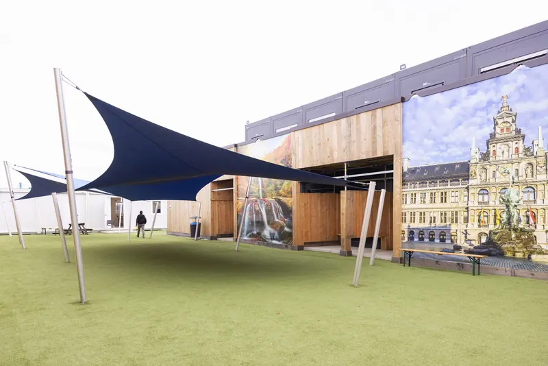 Speelplaats met kunstgras en zonnezeilen tussen de schoolgebouwen